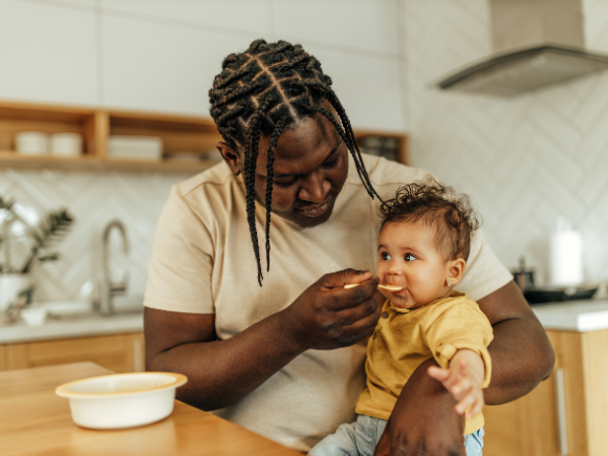 Father feeding their child solids