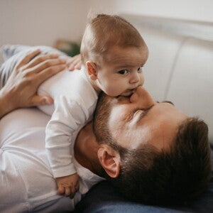 Baby lying on their dad's tummy