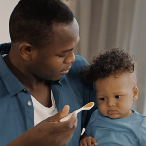 Man feeding baby pureed foods on spoon