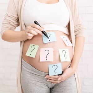 pregnant woman's belly with question marks