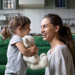 Mother smiling while talking to toddler girl