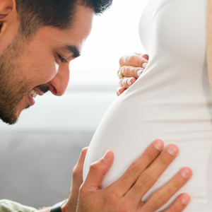 Man hugging womans pregnant stomach