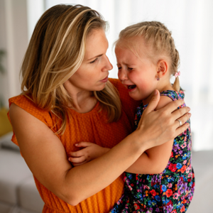 Woman holding her crying daughter