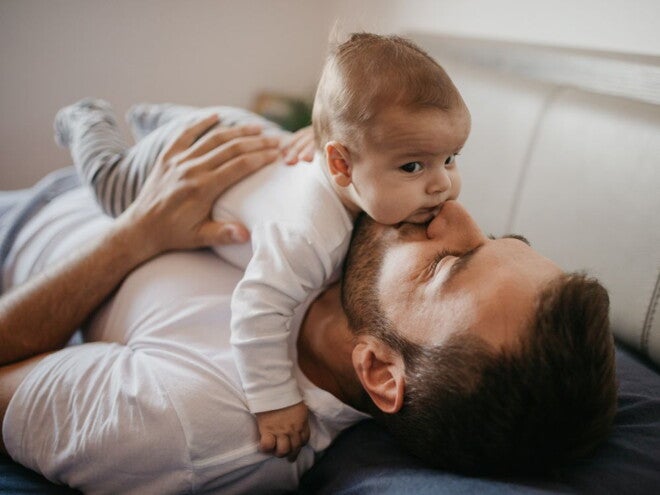 Baby lying on their dad's tummy