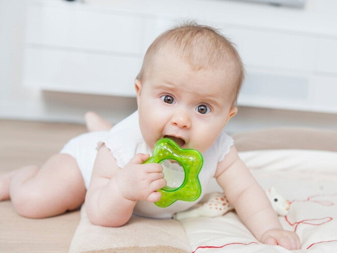 baby tummy time chewing on teething ring